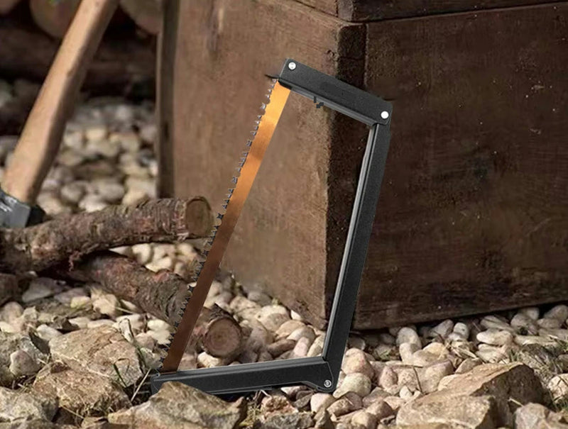 The folding bow saw leaning against a wooden post beside cut branches