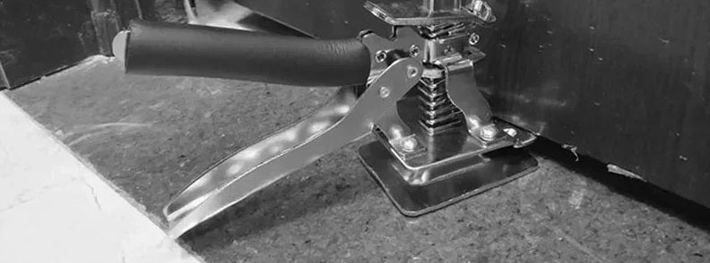A board lifter holding a stone countertop up off its cabinet
