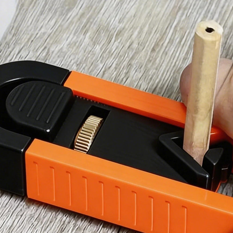 Close view of the slide: the ribbed thumb pad, the brass-colored thumb wheel and a pencil standing in the clamp