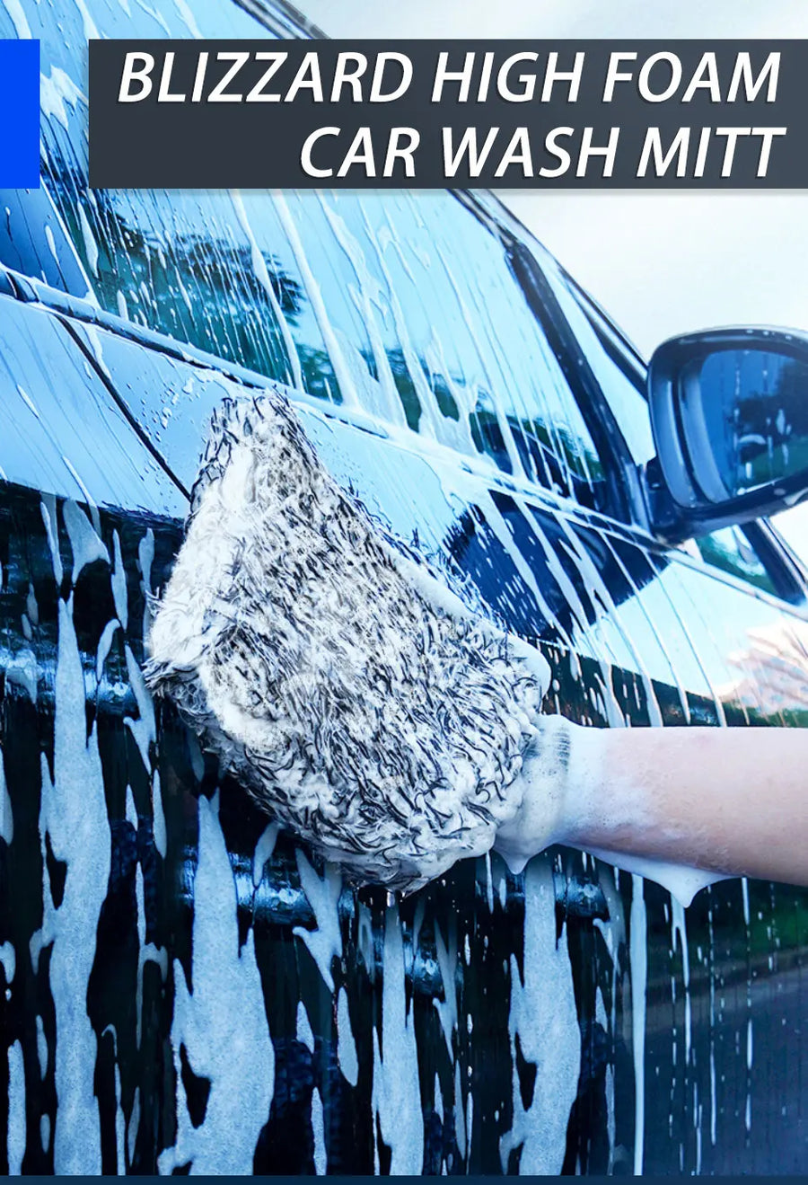 The wash mitt covered in foam on the side of a car