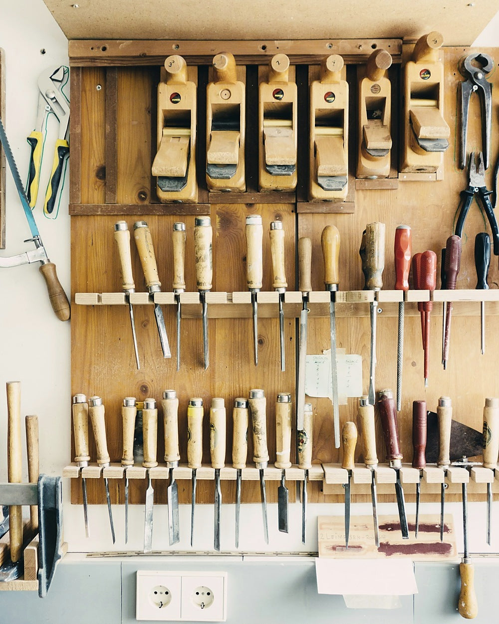 Workshop wall rack holding chisels and hand tools
