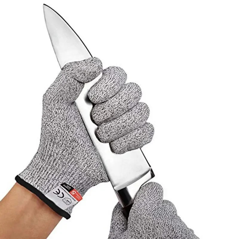 Gloved hand holding a chef's knife by the blade in the maker's staged photo