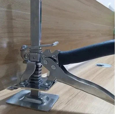 A board lifter raising a floorboard, with a hand on the lever